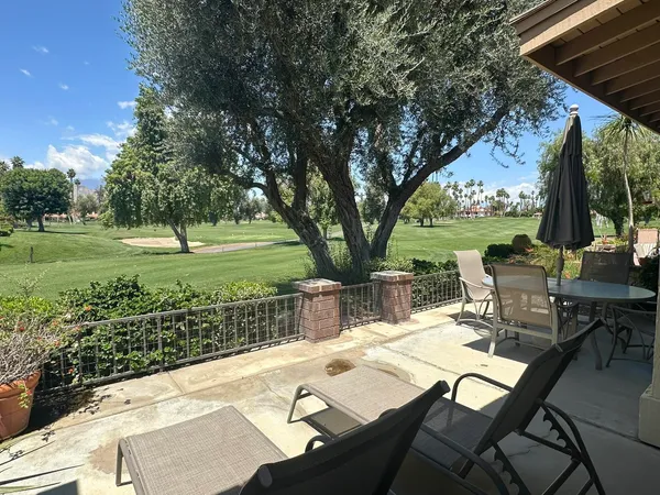 a view of a patio with a table chairs and a backyard