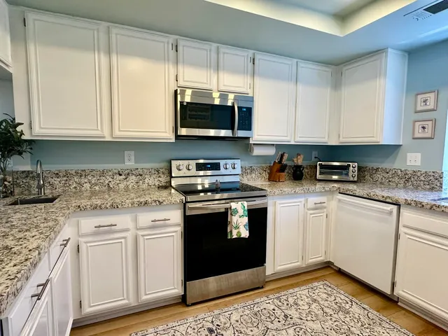 a kitchen with stainless steel appliances granite countertop a stove a sink and a microwave