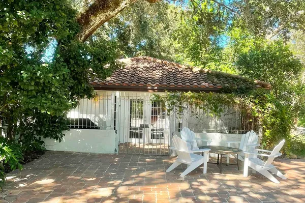 a view of a patio with table and chairs and floor to ceiling window
