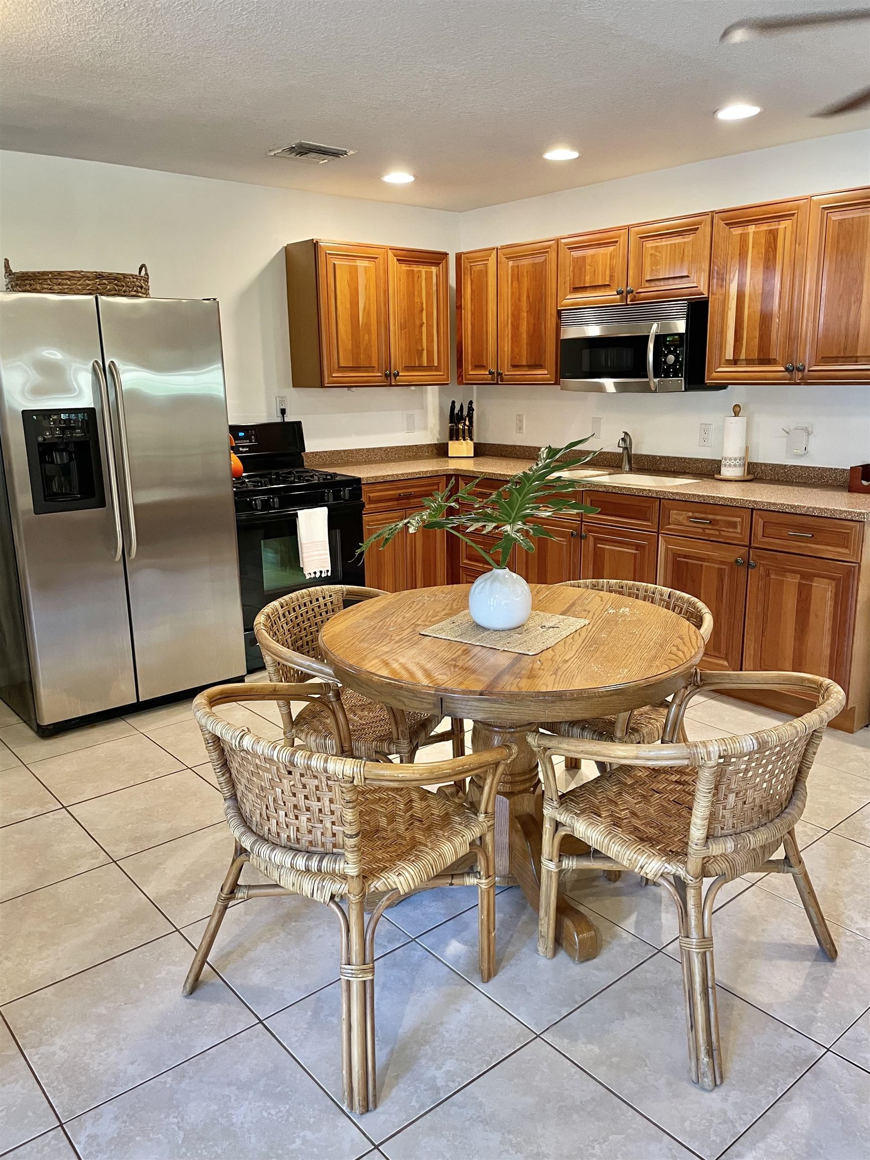 694 16th Street St. Augustine Beach, FL 32080 - Photo 4 of 14 a kitchen with stainless steel appliances kitchen island granite countertop a table chairs and a refrigerator