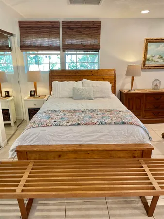 a bedroom with a bed and large windows