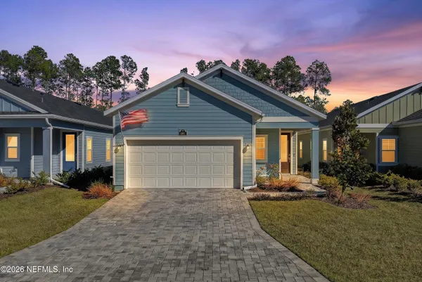 a front view of a house with a yard and potted plants
