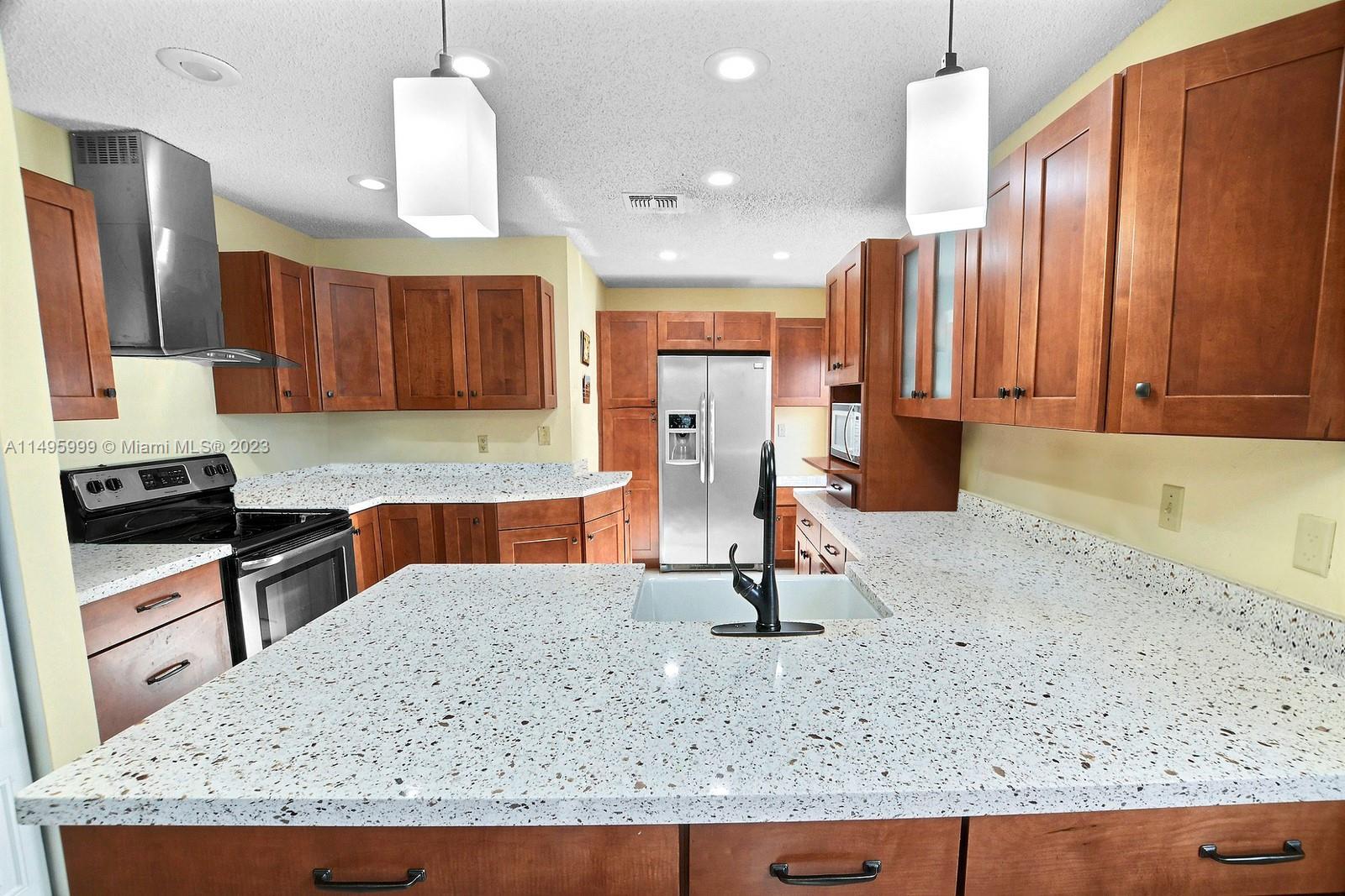 Forest Ridge Cluster Homes Davie, FL 33328 - Photo 14 of 39 a kitchen with kitchen island granite countertop a sink a counter top space and cabinets