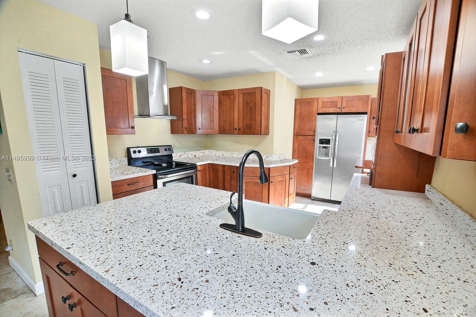 Forest Ridge Cluster Homes Davie, FL 33328 - Photo 15 of 39 a kitchen with stainless steel appliances granite countertop a sink refrigerator and cabinets