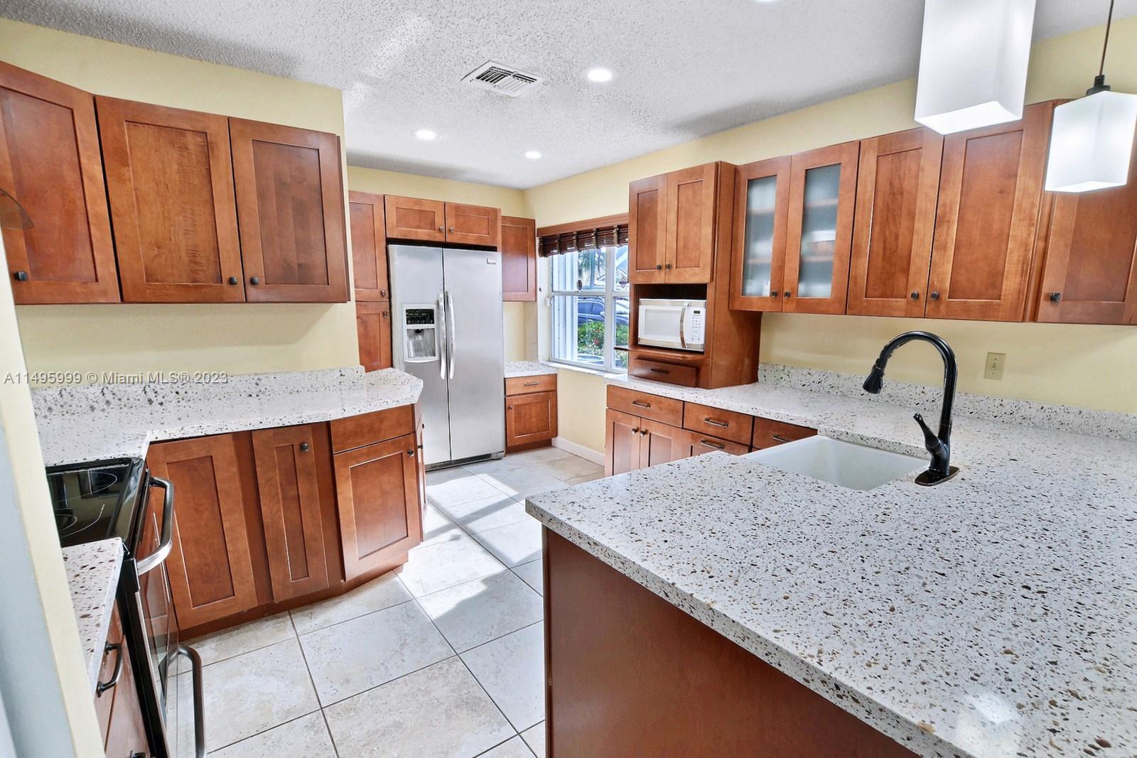Forest Ridge Cluster Homes Davie, FL 33328 - Photo 16 of 39 a kitchen with stainless steel appliances granite countertop a sink a stove and a refrigerator