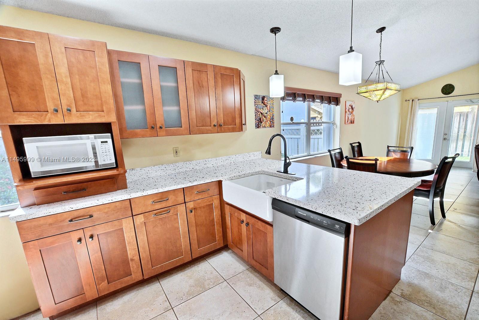 Forest Ridge Cluster Homes Davie, FL 33328 - Photo 17 of 39 a kitchen with stainless steel appliances granite countertop a sink a oven and a dining table with wooden floor