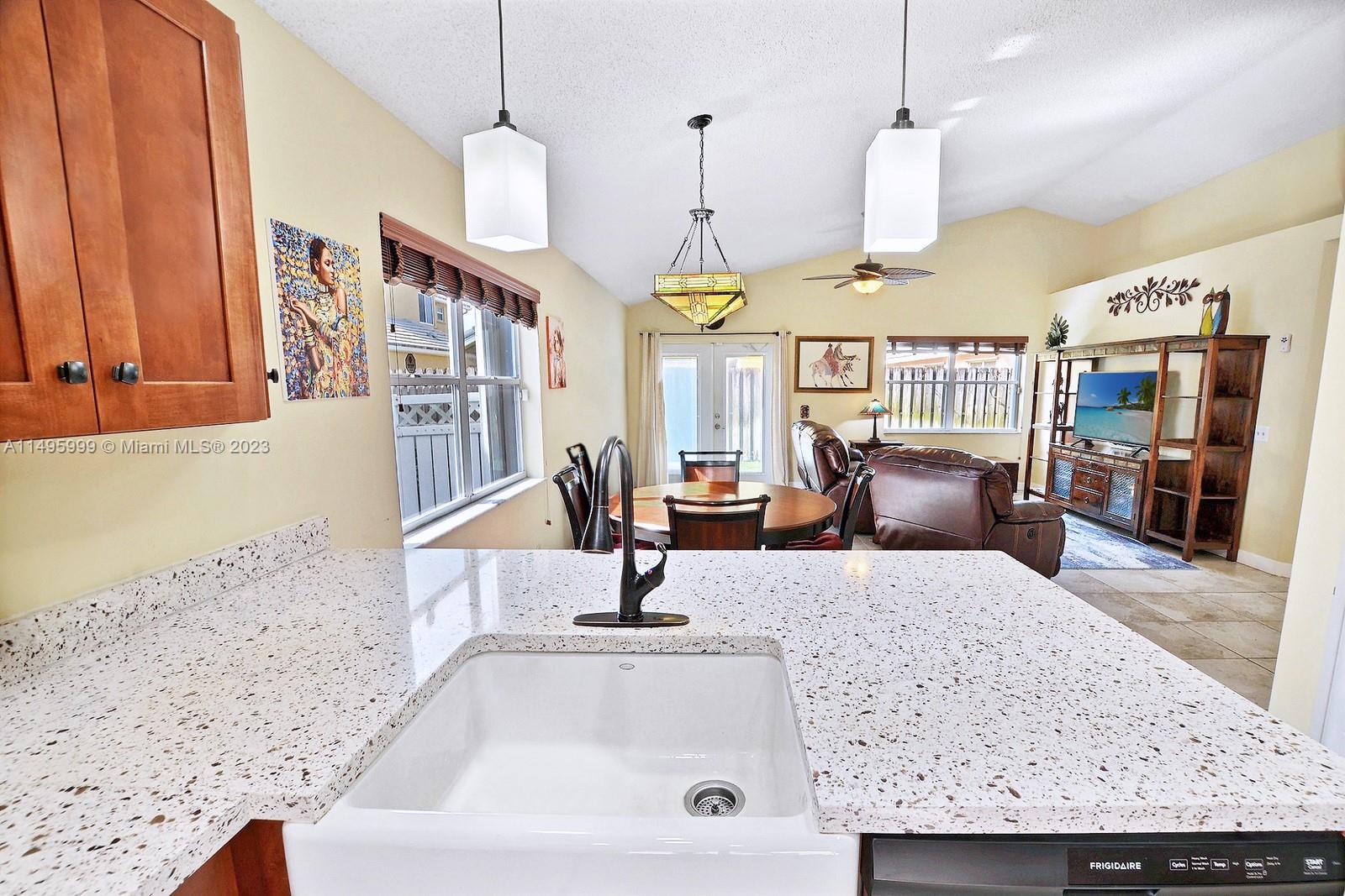 Forest Ridge Cluster Homes Davie, FL 33328 - Photo 18 of 39 a kitchen with a sink a counter and living room view