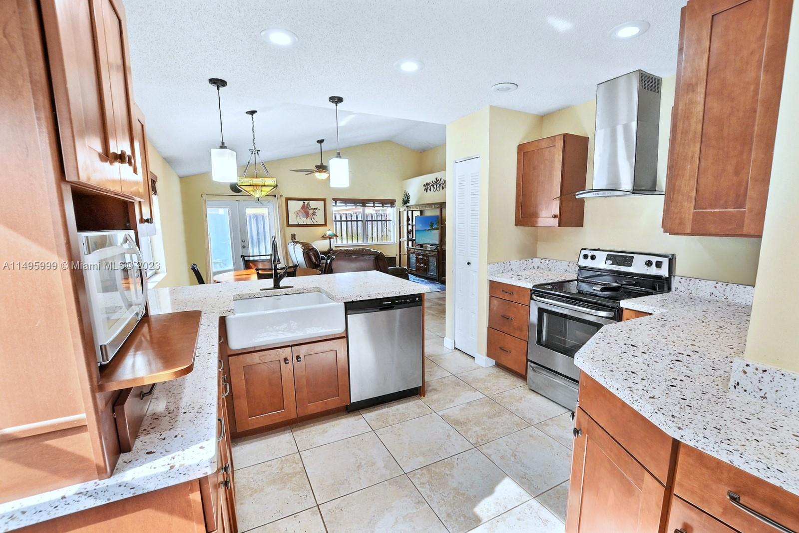 Forest Ridge Cluster Homes Davie, FL 33328 - Photo 19 of 39 a kitchen with stainless steel appliances granite countertop a sink a stove and a refrigerator