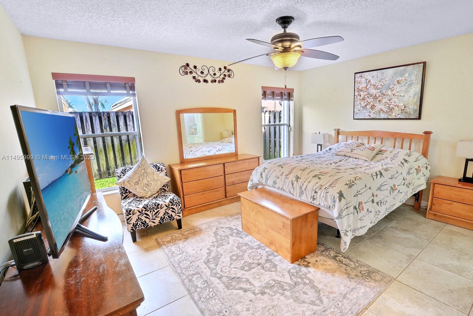 Forest Ridge Cluster Homes Davie, FL 33328 - Photo 21 of 39 a bedroom with a bed and a chandelier