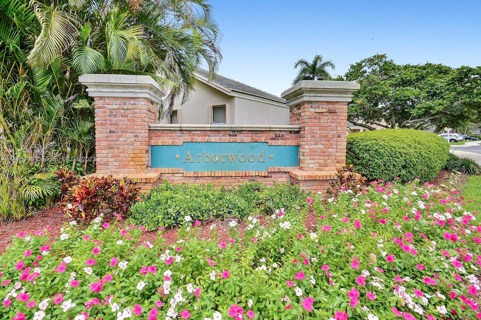 Forest Ridge Cluster Homes Davie, FL 33328 - Photo 34 of 39 a front view of a house with lots of flowers and yard