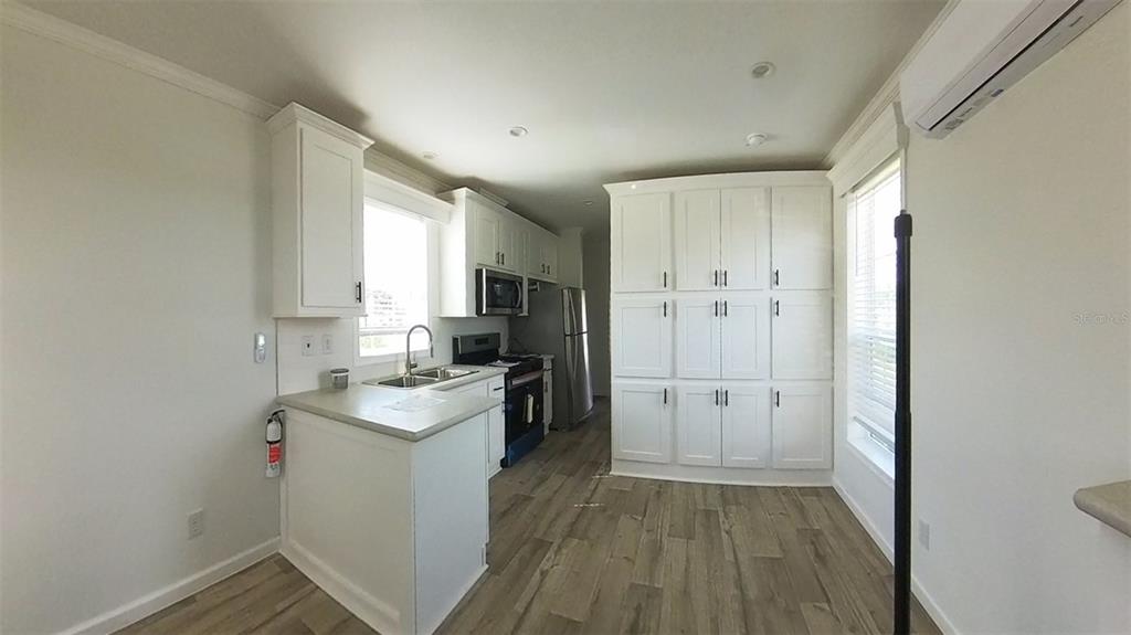 4345 Northwest 27th Place Ocala, FL 34475 - Photo 8 of 39 a kitchen with white cabinets and wooden floor