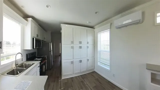 a kitchen with granite countertop a refrigerator a sink and wooden floor