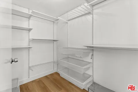 a view of walk in closet with empty racks