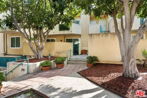 a view of a house with backyard and a tree
