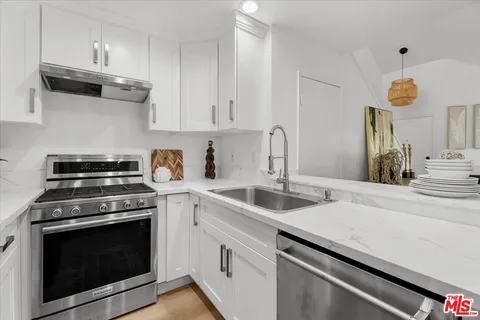 a kitchen with cabinets appliances and a sink
