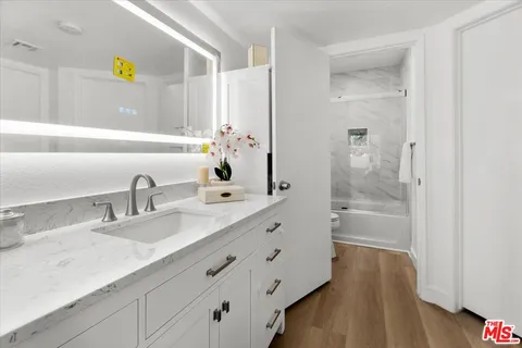 a bathroom with a granite countertop sink mirror and shower