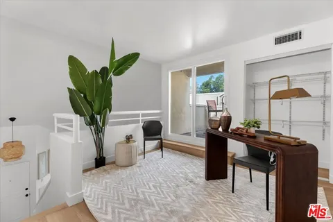 a living room with furniture a potted plant and a lamp