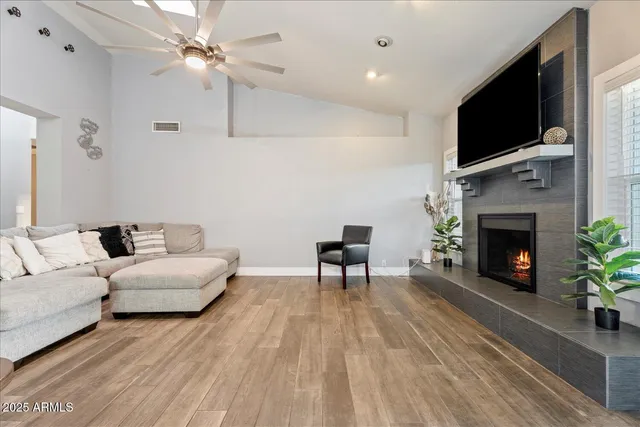 a living room with furniture a flat screen tv and a fireplace