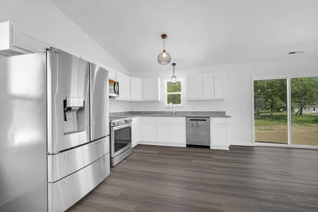 a kitchen with stainless steel appliances a refrigerator sink and cabinets