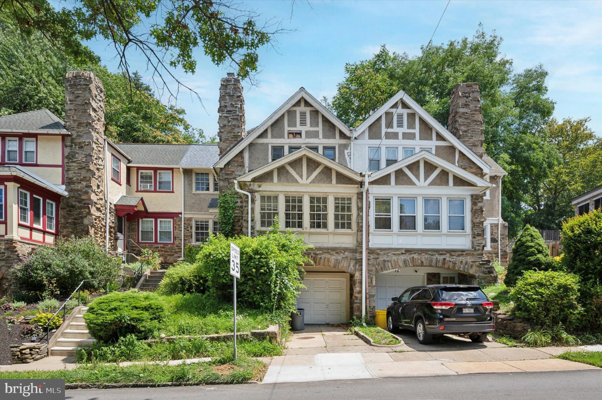 a front view of a house with a yard and potted plants