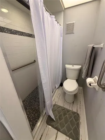 a bathroom with a toilet and a shower