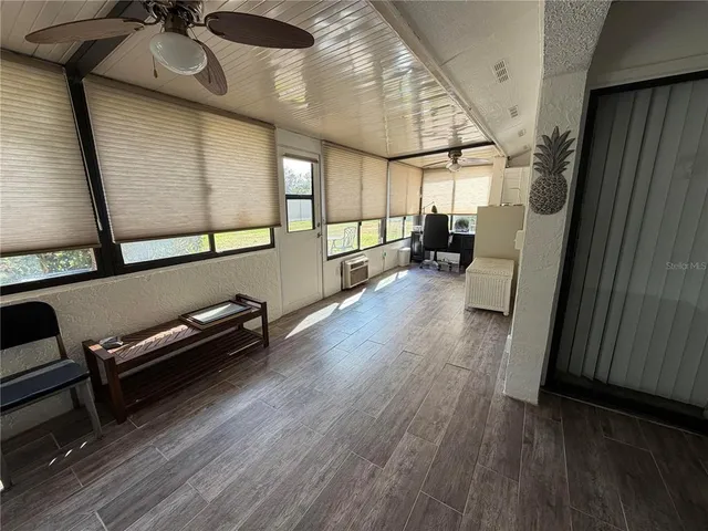 a view of a hallway with wooden floor and furniture