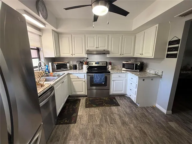 a kitchen with a sink stainless steel appliances and cabinets