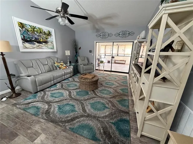 a living room with furniture a flat screen tv and a floor to ceiling window