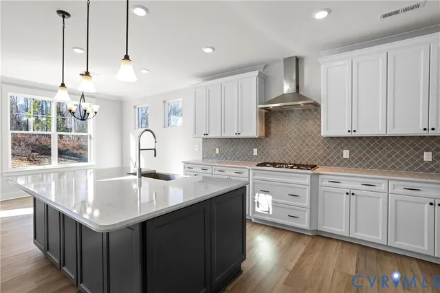 a kitchen with kitchen island granite countertop a sink a counter space appliances and cabinets