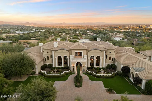 an aerial view of a house with yard and mountain view in back