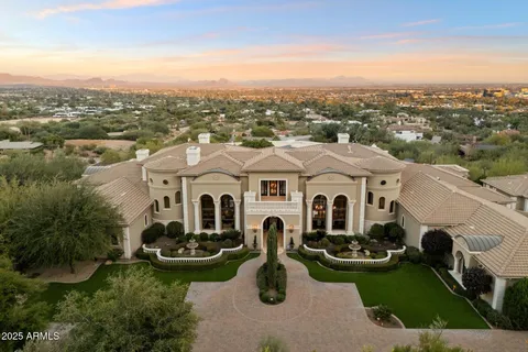 an aerial view of a house with yard and mountain view in back