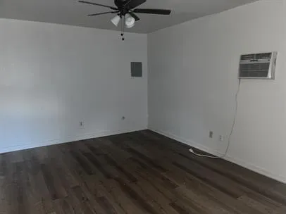an empty room with a ceiling fan and wooden floor
