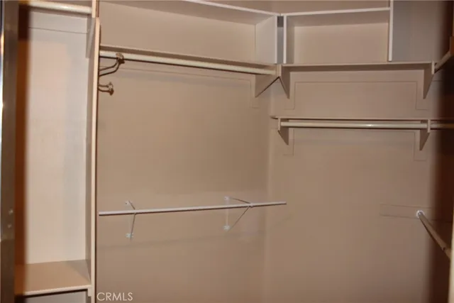 a view of a house with potted plants and a bench