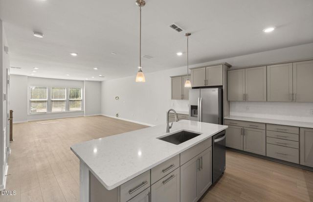 a kitchen with refrigerator and white cabinets
