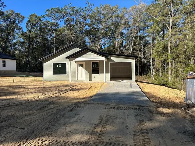 a front view of a house with a yard and trees