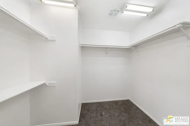 an empty room with a window and a ceiling fan