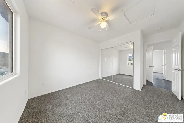 an empty room with fan and entrance