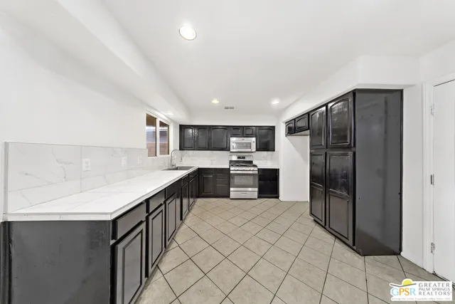 a kitchen with a refrigerator and a stove