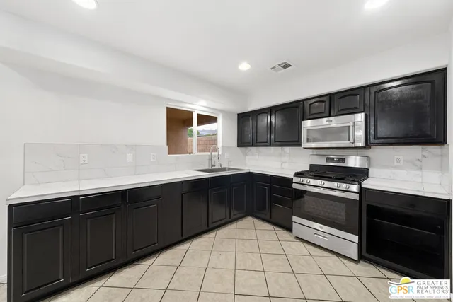 a view of empty room with kitchen and sink