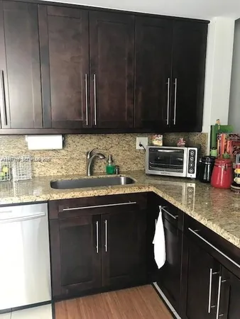 a kitchen with a sink a stove and cabinets