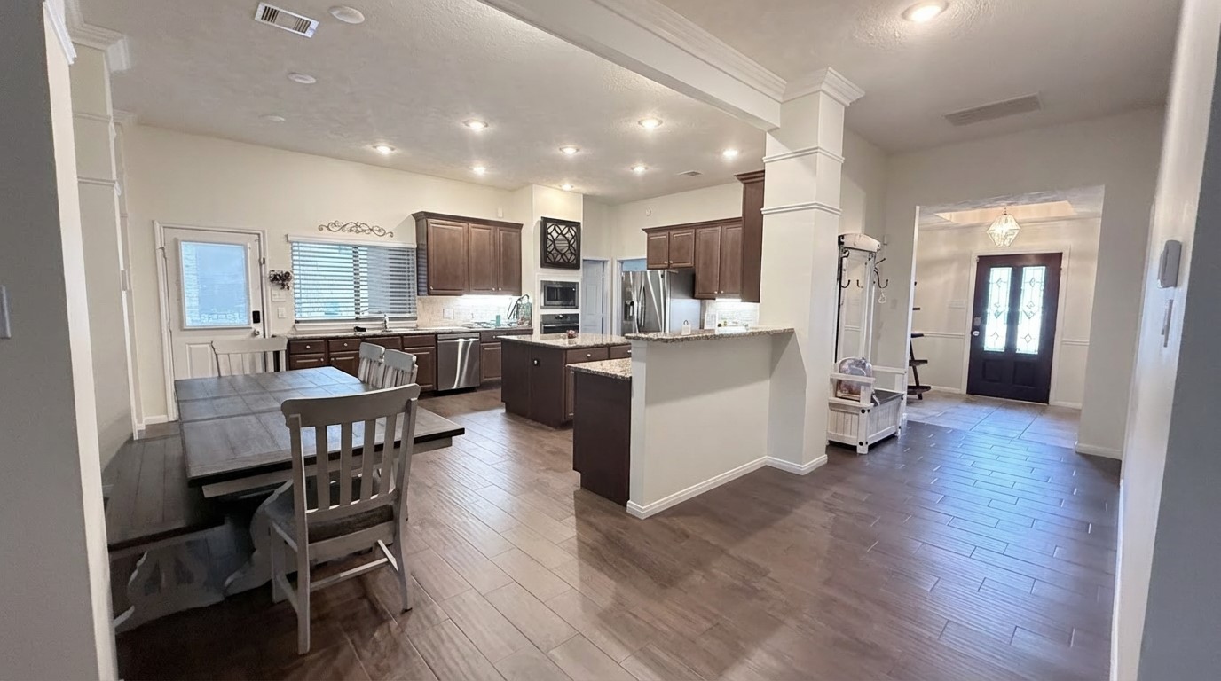 2504 Rosa Rita Drive League City, TX 77573 - Photo 6 of 44 a kitchen with stainless steel appliances kitchen island granite countertop a table chairs cabinets and wooden floor