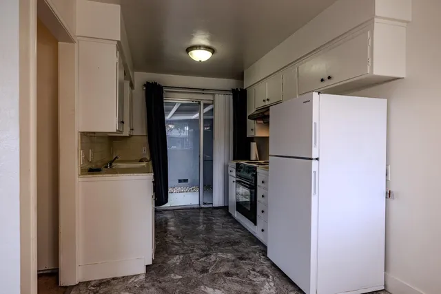a kitchen with a refrigerator a stove top oven and a refrigerator