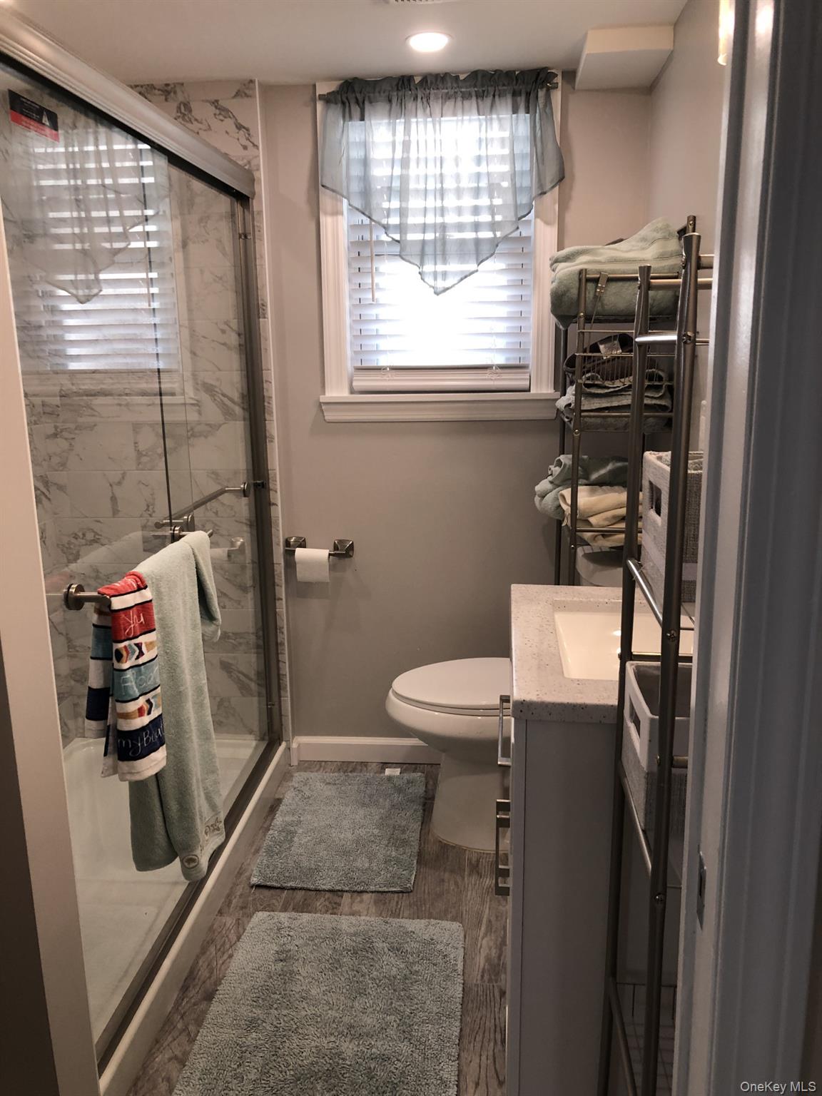 321 West Walnut Street, Unit 2 Long Beach, NY 11561 - Photo 10 of 13 a bathroom with a toilet a sink and a shower