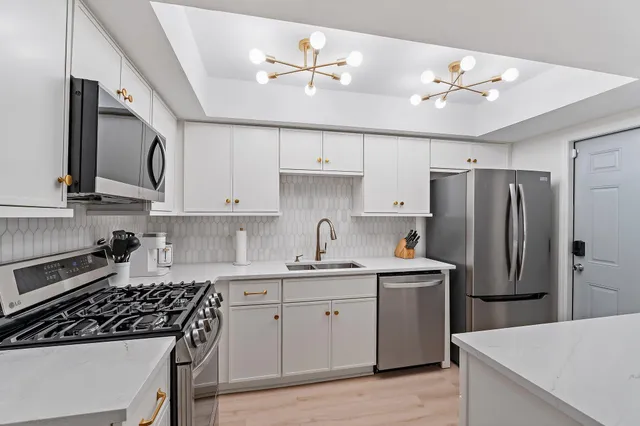 a kitchen with stainless steel appliances a sink stove and refrigerator