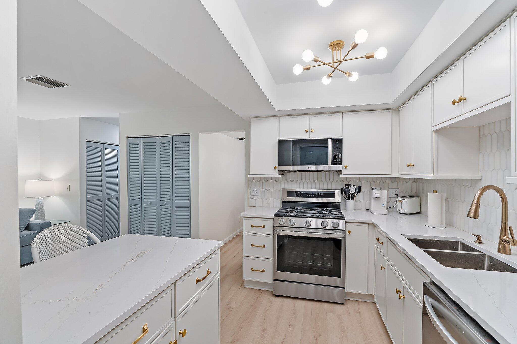 11830 Brier Patch Court Wellington, FL 33414 - Photo 12 of 34 a kitchen with a sink stove and microwave