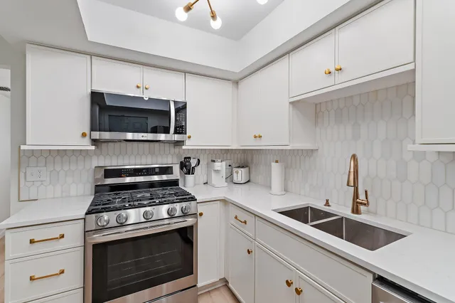 a kitchen with cabinets stainless steel appliances a sink and a counter space