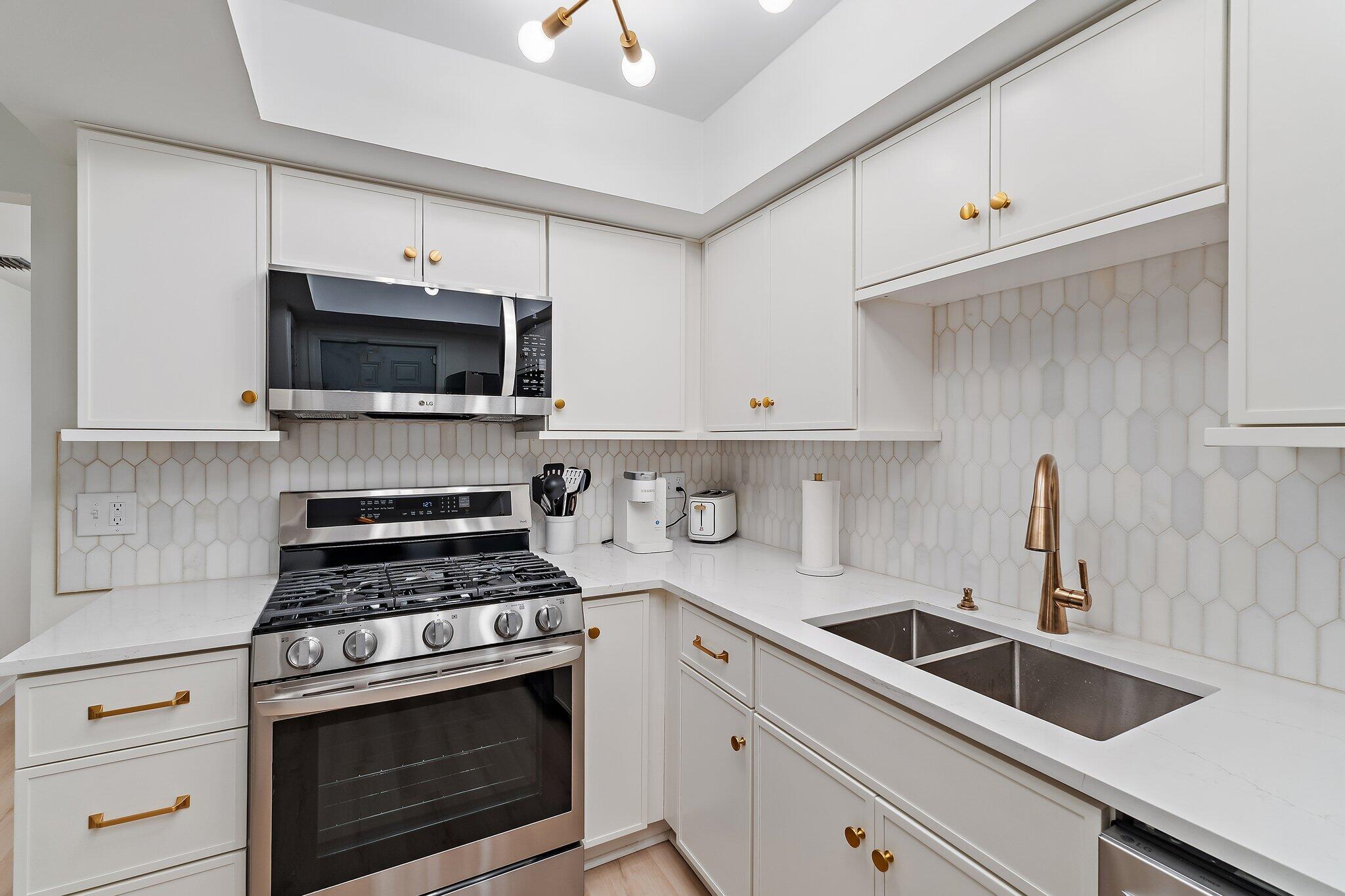 11830 Brier Patch Court Wellington, FL 33414 - Photo 13 of 34 a kitchen with cabinets stainless steel appliances a sink and a counter space