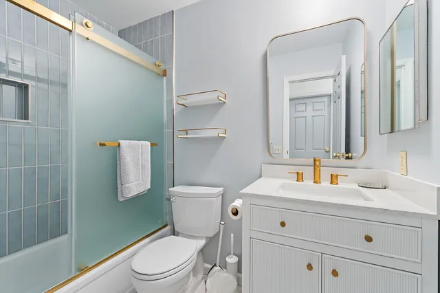 a bathroom with a toilet sink vanity and mirror
