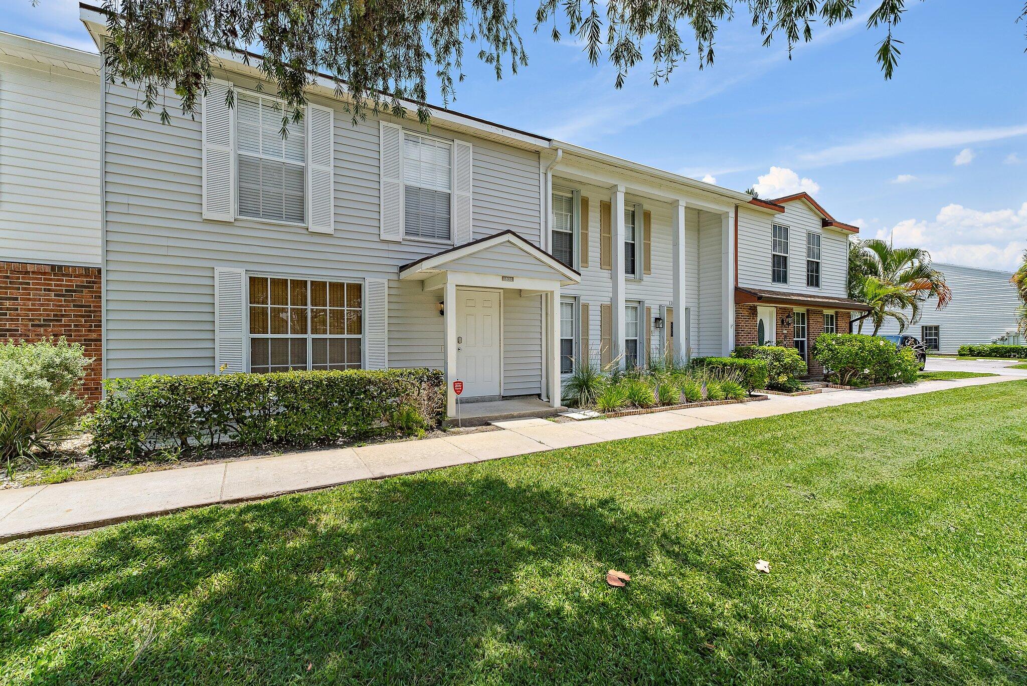 11830 Brier Patch Court Wellington, FL 33414 - Photo 32 of 34 a front view of a house with a yard and garage