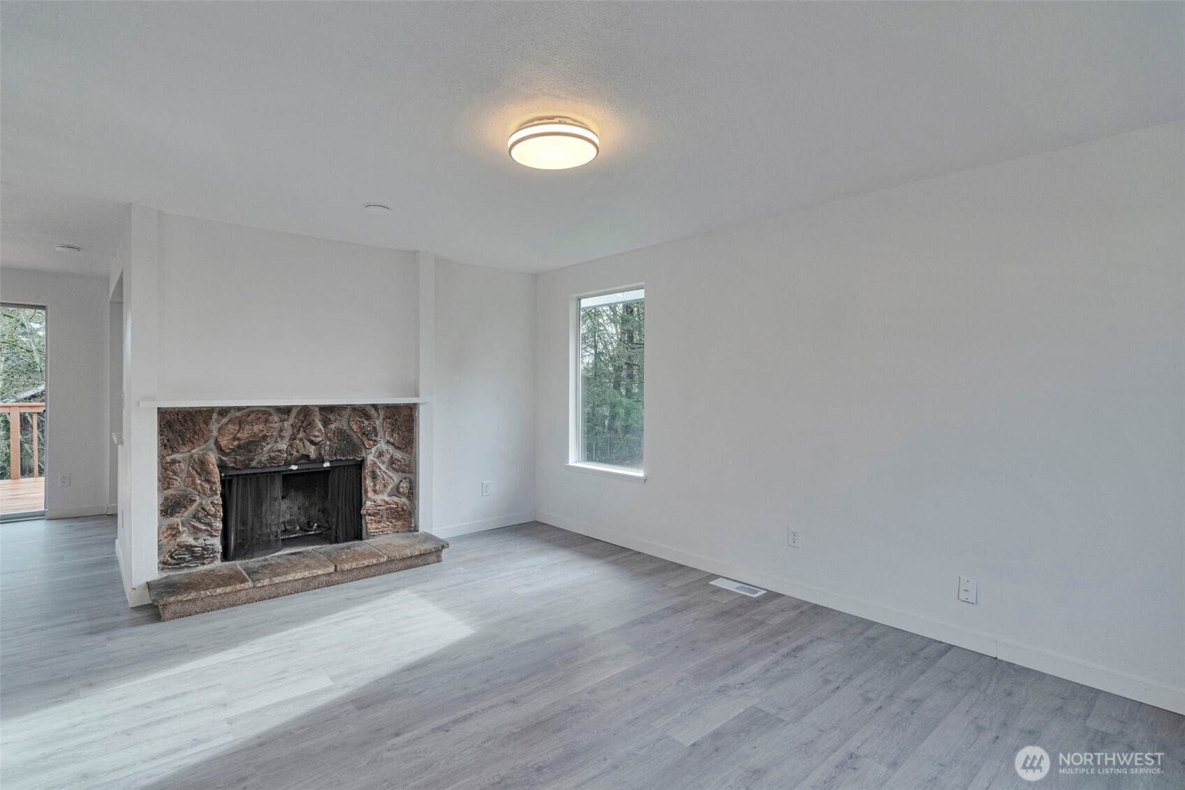 25810 129th Place Southeast Kent, WA 98030 - Photo 3 of 25 an empty room with wooden floor fireplace and window